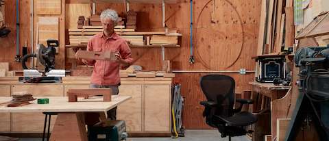 Artist Jesse Schlesinger in his woodworking studio with a black Aeron Chair.