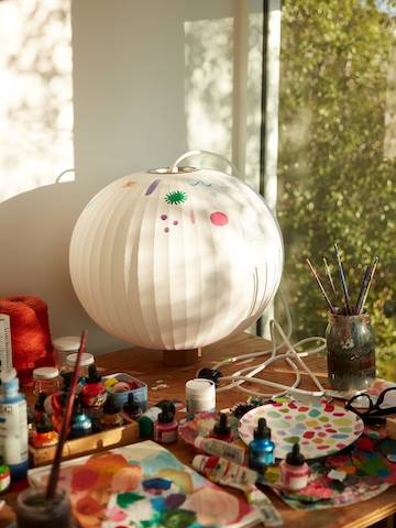 A Nelson Bubble Lamp partially painted by Kindah Khalidy on a table in her studio.