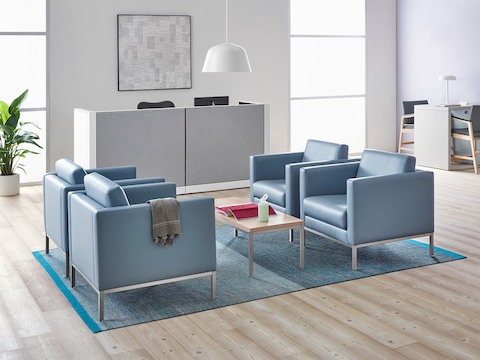 A healthcare reception area featuring four light blue lounge chairs.